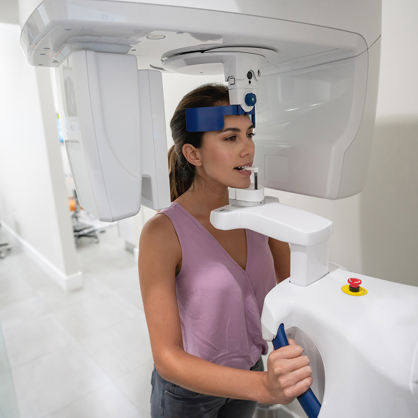 A woman in a dental scanner smiling
