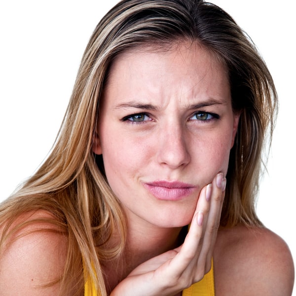 A woman is holding her hand close to the face while experiencing tooth pain