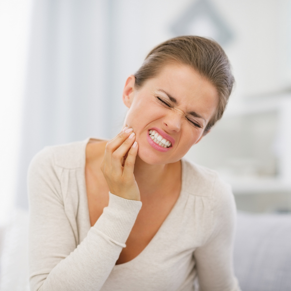 Portrait of a young woman in pain with a toothache