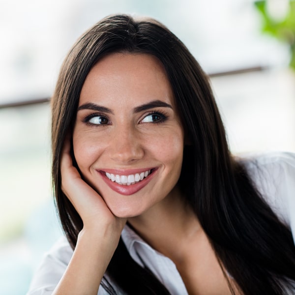 A woman is smiling with her porcelain veneers