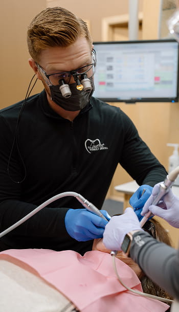 Dental team performing dental procedure on a patient in a dental chair