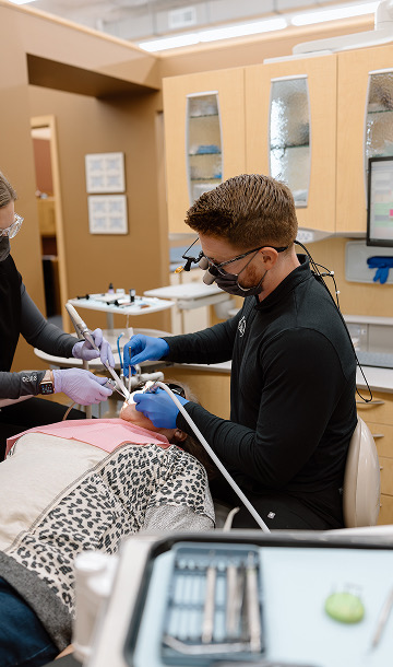 Dentist is at work with a patient in a chair