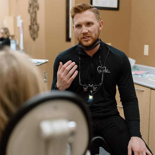 Dentist is smiling while talking to the patient