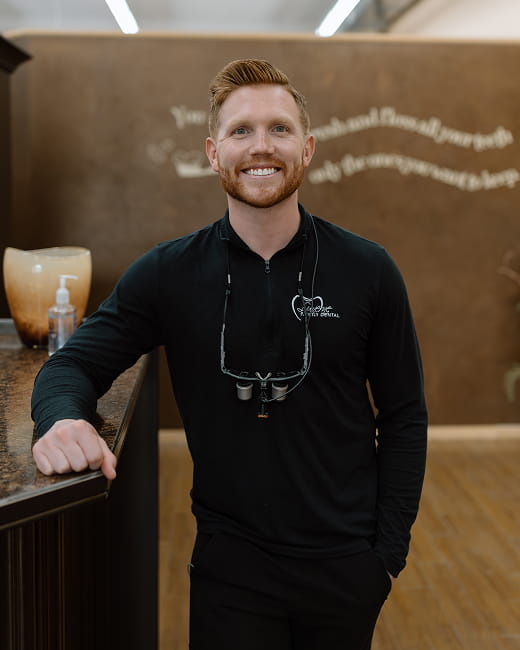 Dr Tanner Brolsma local dentist is happily smiling at front desk