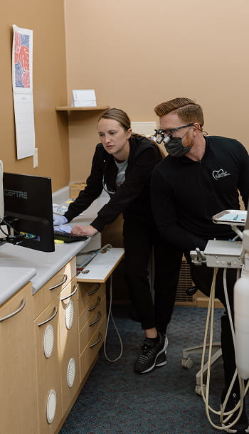 Two dentists looking at monitor